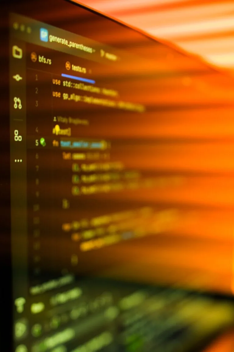 Linhas de código desfocadas em tons âmbar numa tela de computador